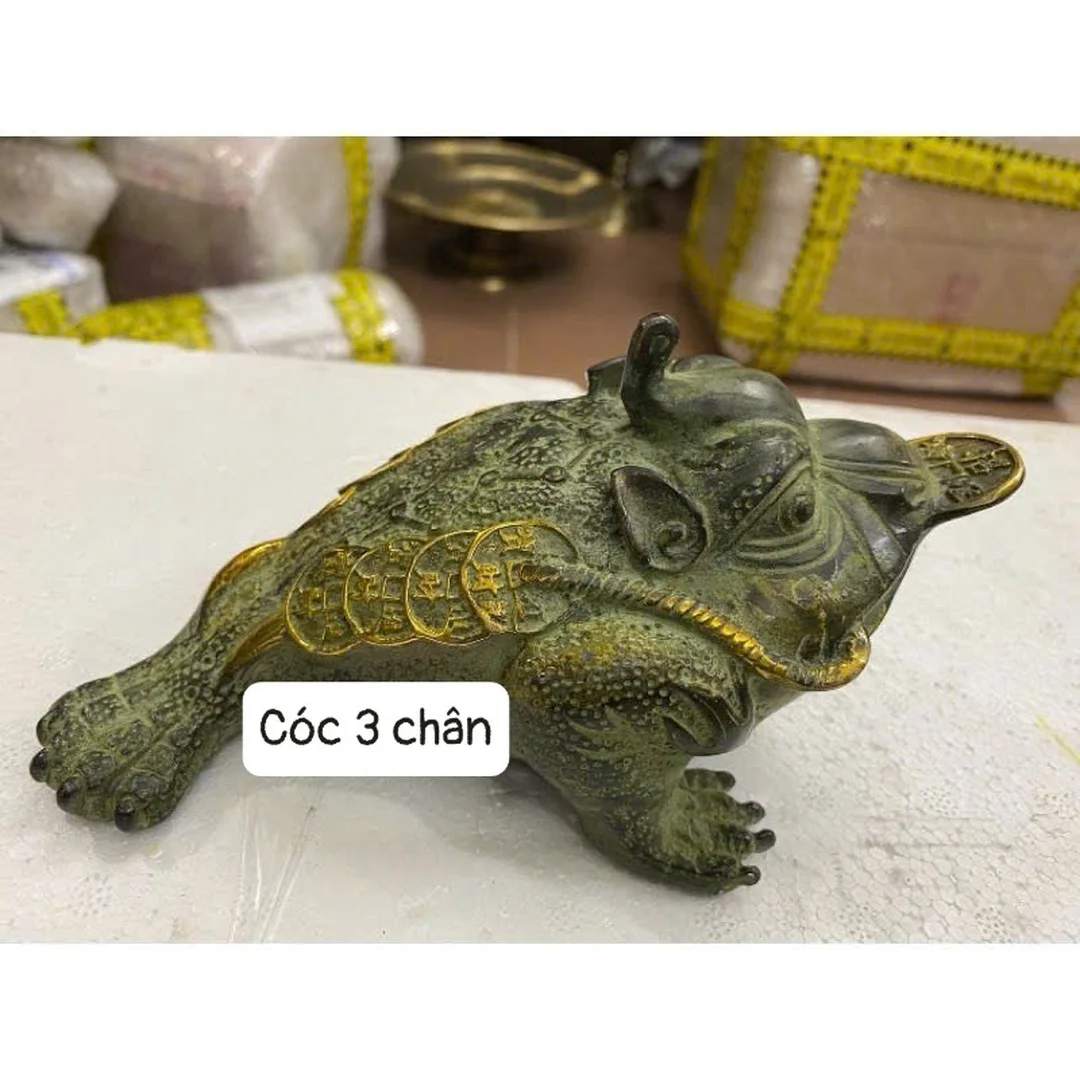 con cóc ba chân màu vàng trên nền sản phẩm phong thủy