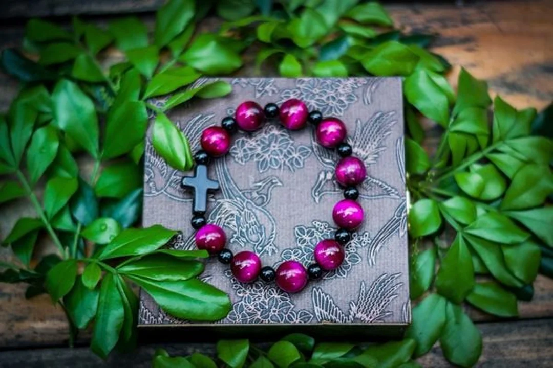vòng tay phong thủy đá mắt hổ hồng đặt trên nền trắng
